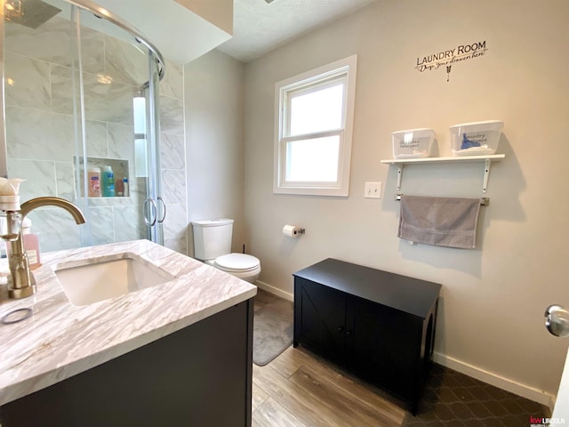 1501 Mildred Ave, Bellevue, NE 68005 - full bath with vanity, baseboards, toilet, a stall shower, and wood finished floors