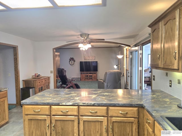 2205 Hidden Canyon Rd, Plattsmouth, NE 68048 - kitchen with a peninsula, ceiling fan, backsplash, an office area, and dark stone countertops