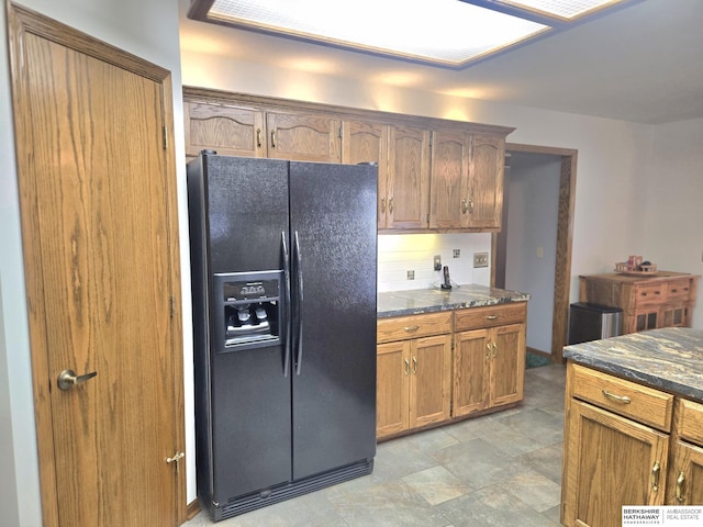 2205 Hidden Canyon Rd, Plattsmouth, NE 68048 - kitchen featuring black fridge, dark stone countertops, and brown cabinetry