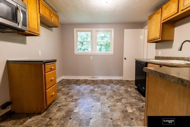 4518 Redick Ave, Omaha, NE 68152 - kitchen with stainless steel microwave, dishwasher, dark countertops, a sink, and a textured ceiling