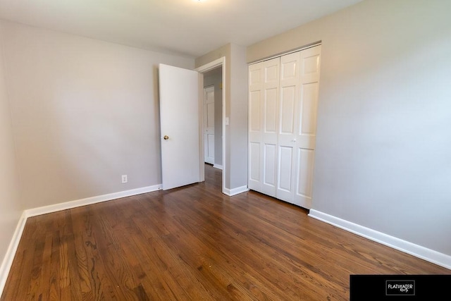 4518 Redick Ave, Omaha, NE 68152 - unfurnished bedroom featuring baseboards, dark wood-type flooring, and a closet
