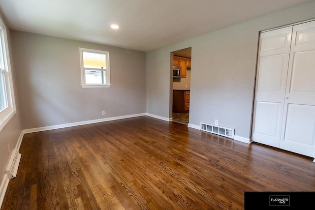 4518 Redick Ave, Omaha, NE 68152 - unfurnished bedroom featuring dark wood-type flooring, baseboards, baseboard heating, a closet, and recessed lighting