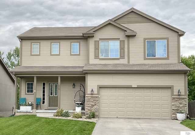 1609 N 208th St, Elkhorn, NE 68022 - view of front of house featuring covered porch, a front lawn, driveway, a garage, and stone siding