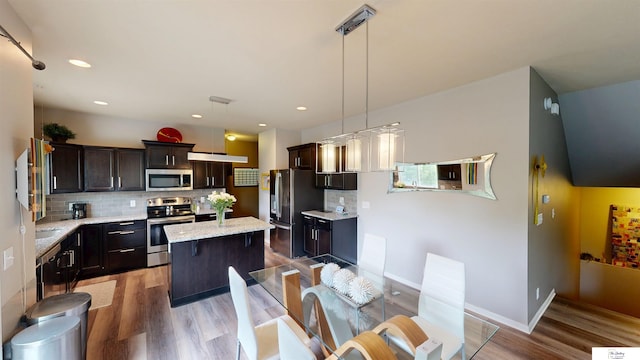 1609 N 208th St, Elkhorn, NE 68022 - kitchen with stainless steel appliances, a kitchen island, light wood-type flooring, decorative backsplash, and recessed lighting