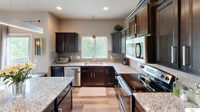 1609 N 208th St, Elkhorn, NE 68022 - kitchen with stainless steel appliances, a sink, light wood-type flooring, dark brown cabinets, and light stone counters