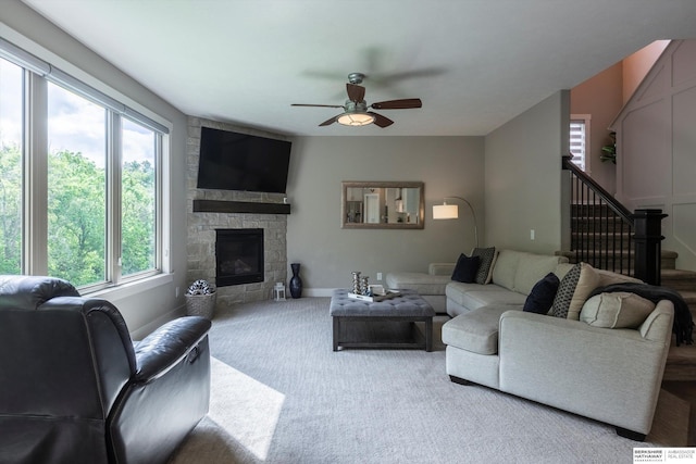 2203 N 188th Ave, Elkhorn, NE 68022 - carpeted living area with ceiling fan, stairs, a stone fireplace, and baseboards