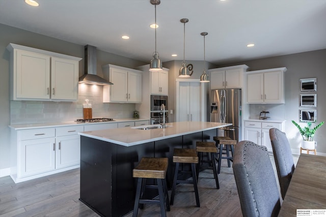 2203 N 188th Ave, Elkhorn, NE 68022 - kitchen with wall chimney exhaust hood, stainless steel appliances, a kitchen island with sink, a sink, and white cabinetry