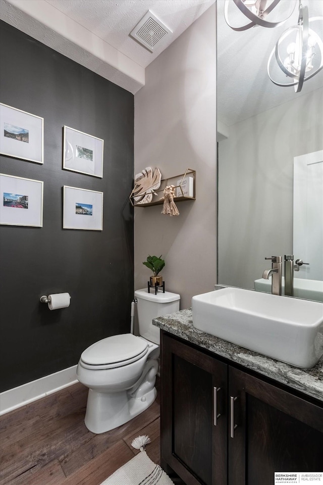 2203 N 188th Ave, Elkhorn, NE 68022 - half bathroom with toilet, wood finished floors, vanity, baseboards, and a chandelier
