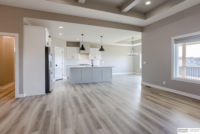 3938 S 207th St, Elkhorn, NE 68022 - unfurnished living room featuring light wood-type flooring, a chandelier, baseboards, a sink, and recessed lighting