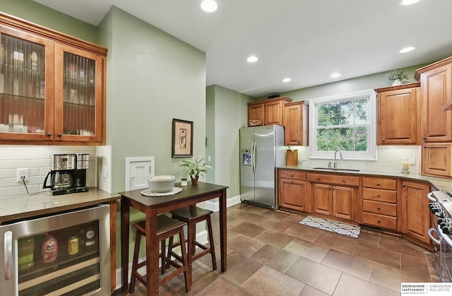 5119 Hamilton St, Omaha, NE 68132 - kitchen with beverage cooler, appliances with stainless steel finishes, a sink, decorative backsplash, and recessed lighting