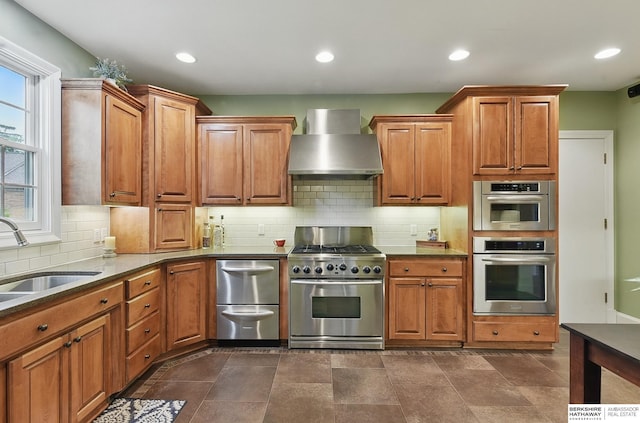 5119 Hamilton St, Omaha, NE 68132 - kitchen with wall chimney range hood, stainless steel appliances, a sink, brown cabinets, and recessed lighting