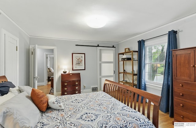5119 Hamilton St, Omaha, NE 68132 - bedroom featuring crown molding, light wood-style floors, a barn door, and baseboards