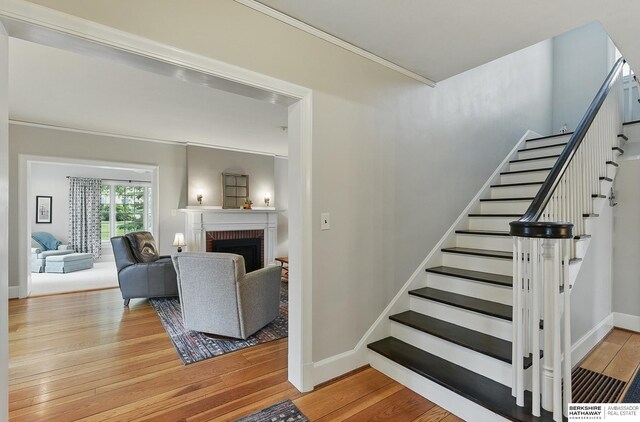 5119 Hamilton St, Omaha, NE 68132 - staircase featuring wood finished floors, ornamental molding, baseboards, and a fireplace