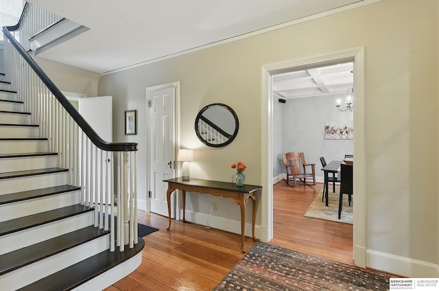 5119 Hamilton St, Omaha, NE 68132 - entryway featuring wood finished floors, a chandelier, stairway, baseboards, and crown molding