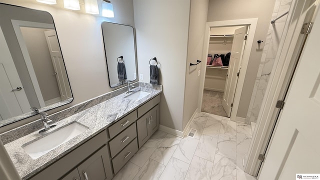 12667 161st Ave, Bennington, NE 68007 - full bath with marble look tiles, double vanity, a walk in closet, baseboards, and a shower
