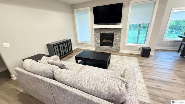 12667 161st Ave, Bennington, NE 68007 - living area featuring baseboards, a stone fireplace, and wood finished floors