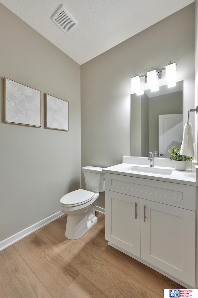 350 N 105th St, Lincoln, NE 68527 - half bathroom featuring toilet, wood finished floors, vanity, and baseboards