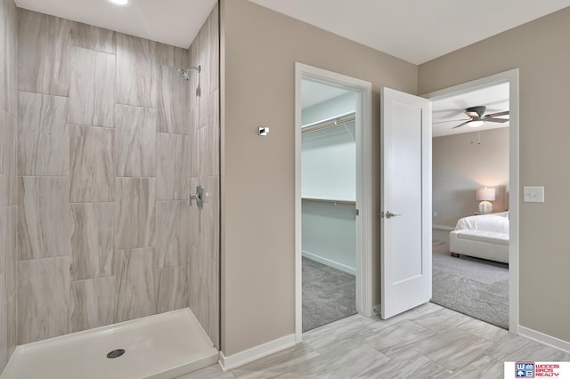 350 N 105th St, Lincoln, NE 68527 - ensuite bathroom featuring tiled shower, baseboards, a ceiling fan, and a spacious closet