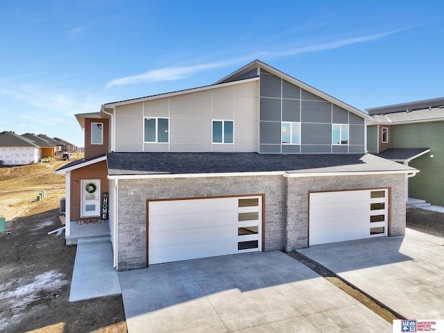 350 N 105th St, Lincoln, NE 68527 - modern home featuring concrete driveway, a garage, and a shingled roof