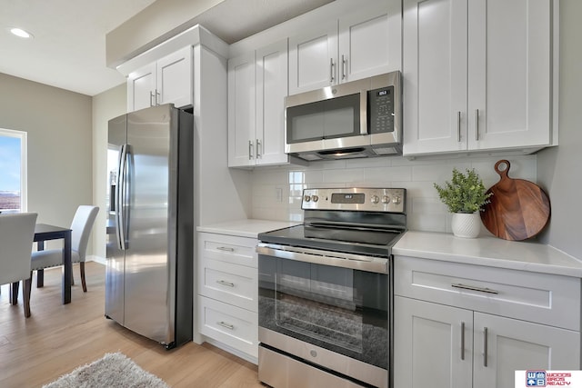 350 N 105th St, Lincoln, NE 68527 - kitchen featuring stainless steel appliances, light wood-type flooring, decorative backsplash, light countertops, and white cabinets