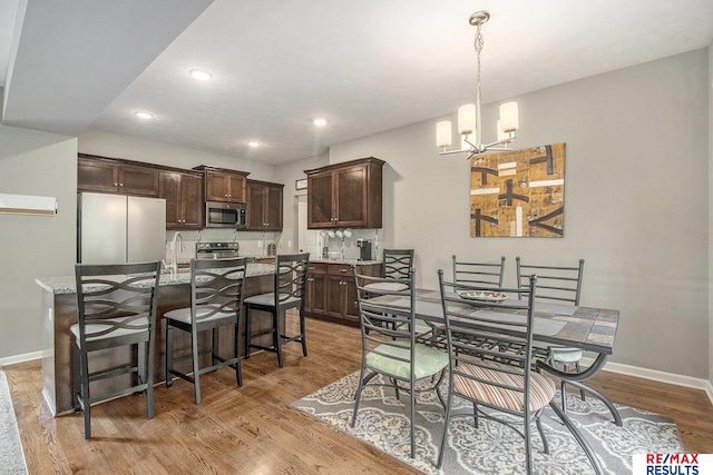 10202 N 152nd Ave, Bennington, NE 68007 - dining space with a chandelier, light wood-type flooring, baseboards, and recessed lighting