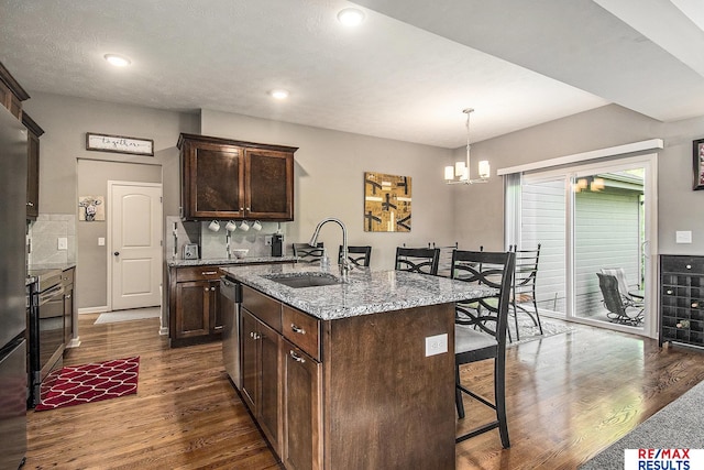 10202 N 152nd Ave, Bennington, NE 68007 - kitchen featuring a sink, appliances with stainless steel finishes, dark wood-style floors, a breakfast bar, and light stone counters