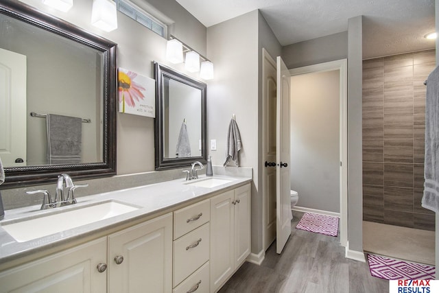 10202 N 152nd Ave, Bennington, NE 68007 - full bath with toilet, double vanity, a walk in shower, and wood finished floors