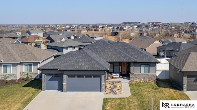 7316 Gerald Ave, Lincoln, NE 68516 - view of front facade featuring a residential view, stone siding, a garage, a shingled roof, and driveway