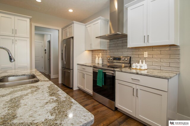 7316 Gerald Ave, Lincoln, NE 68516 - kitchen featuring stainless steel appliances, wall chimney range hood, a sink, recessed lighting, and white cabinetry