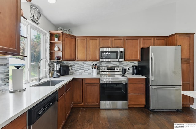 5135 N 159th Cir, Omaha, NE 68116 - kitchen featuring stainless steel appliances, a sink, vaulted ceiling, brown cabinetry, and light countertops