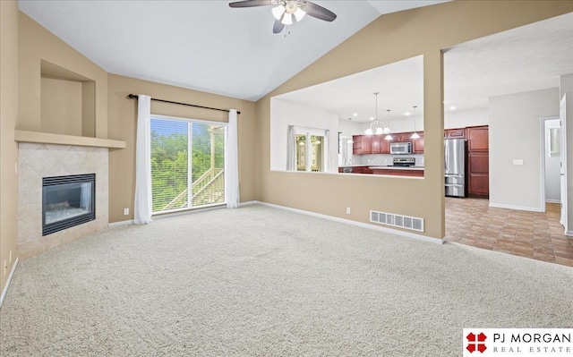 6713 N 148th St, Omaha, NE 68116 - unfurnished living room with light carpet, a chandelier, a ceiling fan, a tile fireplace, and vaulted ceiling