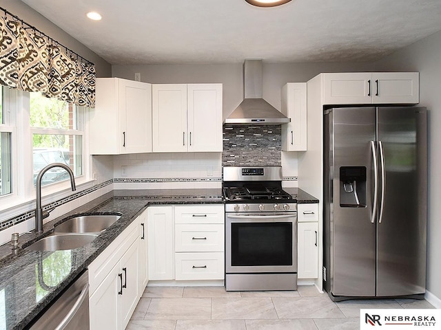 2000 N 53rd St, Lincoln, NE 68504 - kitchen with stainless steel appliances, wall chimney range hood, white cabinets, dark stone countertops, and decorative backsplash