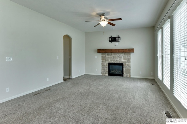 18337 Polk St, Omaha, NE 68135 - unfurnished living room with a ceiling fan, arched walkways, carpet floors, and a stone fireplace