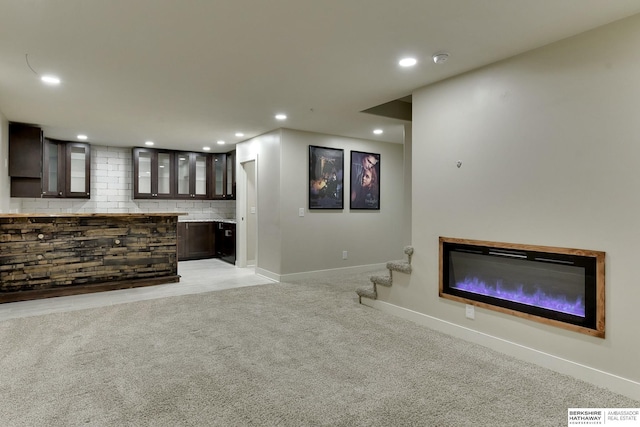 18337 Polk St, Omaha, NE 68135 - unfurnished living room featuring baseboards, recessed lighting, light carpet, a glass covered fireplace, and stairs