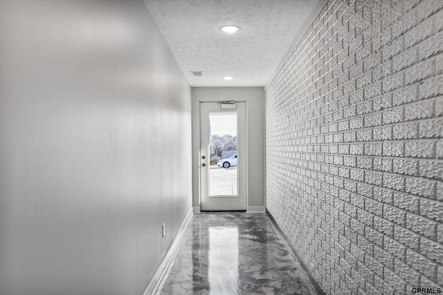 636 N 46th St, Omaha, NE 68132 - corridor featuring a textured ceiling, baseboards, brick wall, and an accent wall