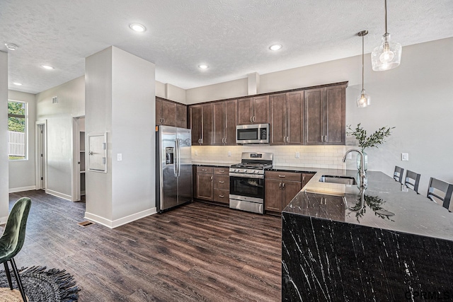 636 N 46th St, Omaha, NE 68132 - kitchen with appliances with stainless steel finishes, a sink, dark wood-type flooring, dark brown cabinetry, and backsplash