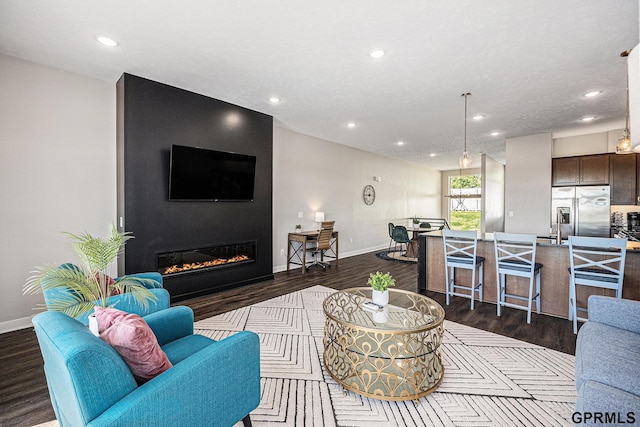 636 N 46th St, Omaha, NE 68132 - living room with dark wood-style flooring, a glass covered fireplace, recessed lighting, and baseboards