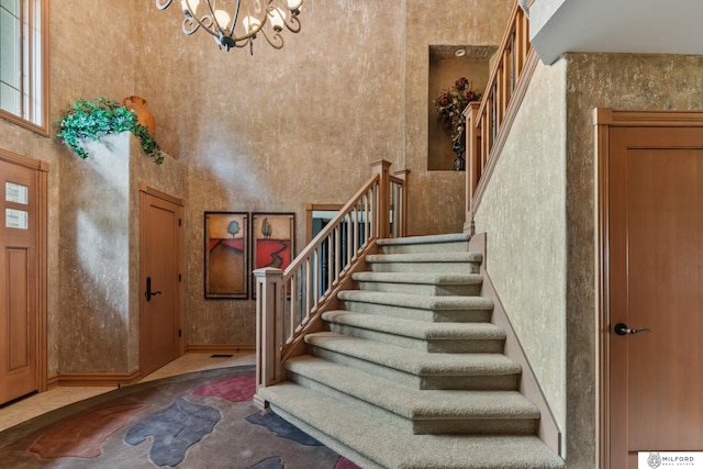 4725 S 184th Plz, Omaha, NE 68135 - foyer with stairs, a high ceiling, and a chandelier