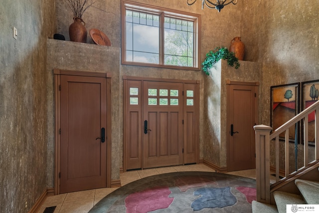 4725 S 184th Plz, Omaha, NE 68135 - entryway with tile patterned flooring, stairs, a towering ceiling, a chandelier, and baseboards