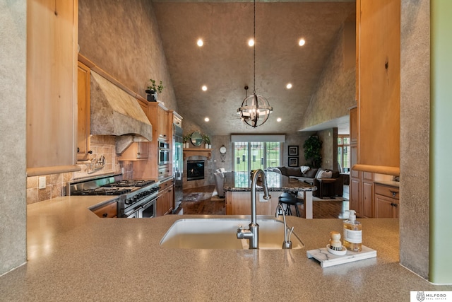 4725 S 184th Plz, Omaha, NE 68135 - kitchen with stainless steel appliances, open floor plan, a sink, a glass covered fireplace, and recessed lighting