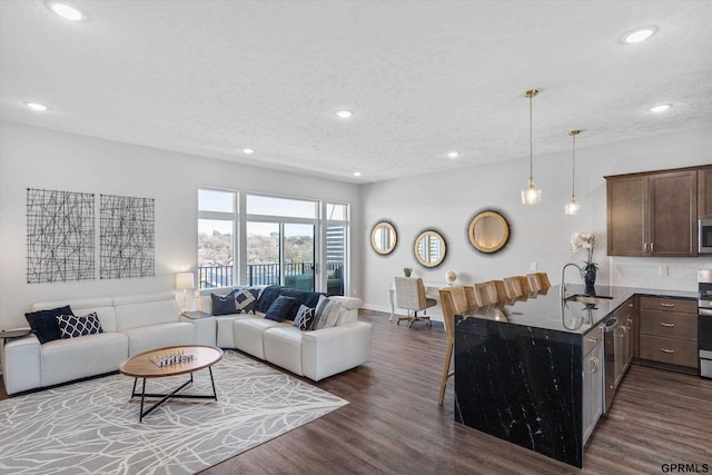 630 N 46th St, Omaha, NE 68132 - living room with dark wood finished floors, recessed lighting, a textured ceiling, and baseboards