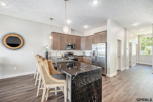 630 N 46th St, Omaha, NE 68132 - kitchen with appliances with stainless steel finishes, a textured ceiling, a sink, a peninsula, and wood finished floors