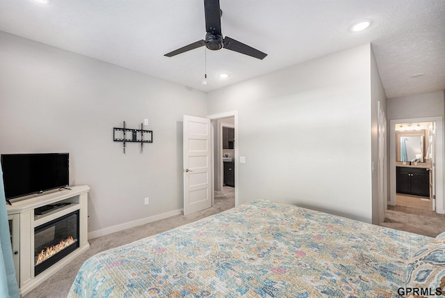 630 N 46th St, Omaha, NE 68132 - carpeted bedroom with a glass covered fireplace, baseboards, recessed lighting, ensuite bath, and a ceiling fan