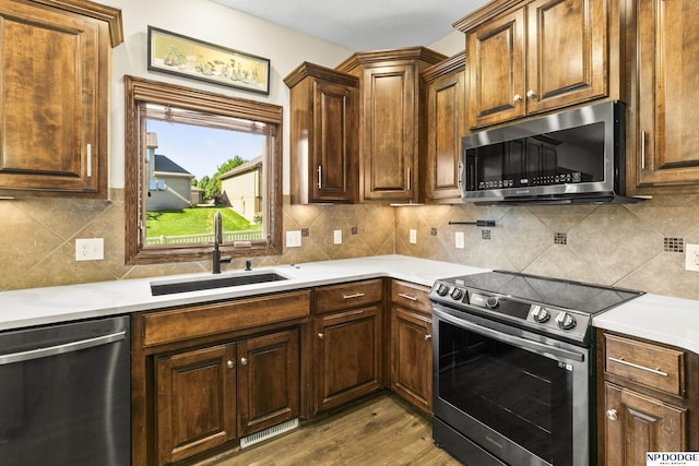 19677 Lamont St, Omaha, NE 68130 - kitchen with stainless steel appliances, a sink, light wood-style floors, and light countertops