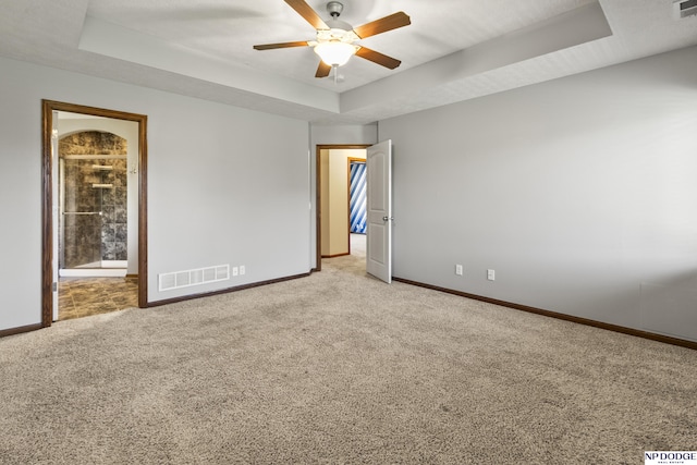 19677 Lamont St, Omaha, NE 68130 - spare room with a tray ceiling, baseboards, a ceiling fan, and light colored carpet