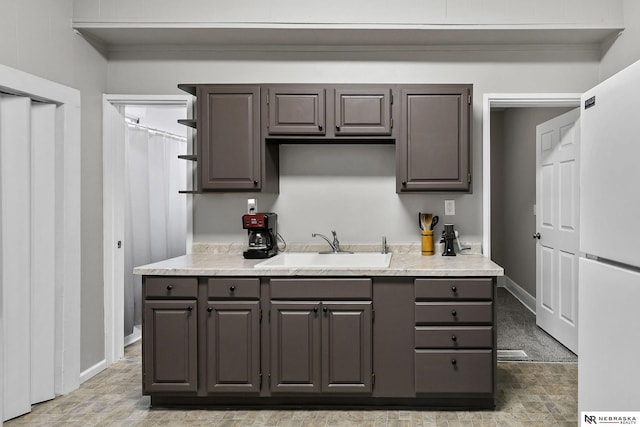 6633 Platte Ave, Lincoln, NE 68507 - kitchen featuring a sink, freestanding refrigerator, light countertops, and baseboards