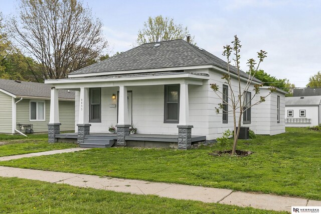 6633 Platte Ave, Lincoln, NE 68507 - bungalow-style house featuring a porch, a shingled roof, cooling unit, and a front lawn