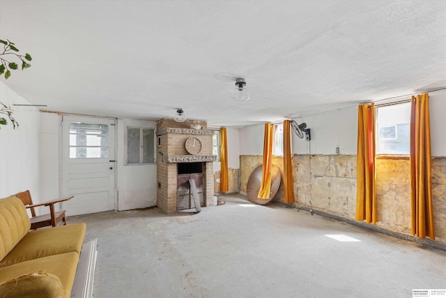 712 Bancroft St, Omaha, NE 68108 - unfurnished living room featuring concrete flooring and a brick fireplace