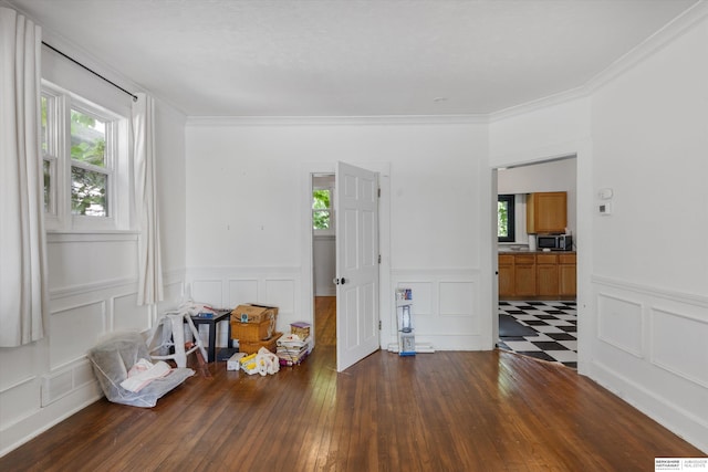 712 Bancroft St, Omaha, NE 68108 - unfurnished room featuring plenty of natural light, wainscoting, a decorative wall, dark wood-style floors, and ornamental molding