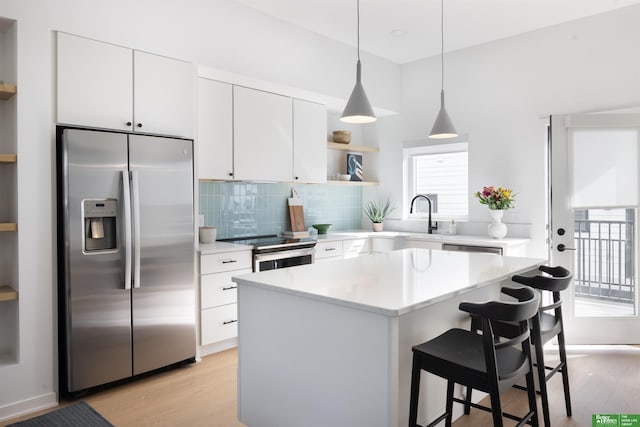 5301 Elmwood Plz, Omaha, NE 68106 - kitchen featuring stainless steel appliances, open shelves, light wood-style floors, and tasteful backsplash